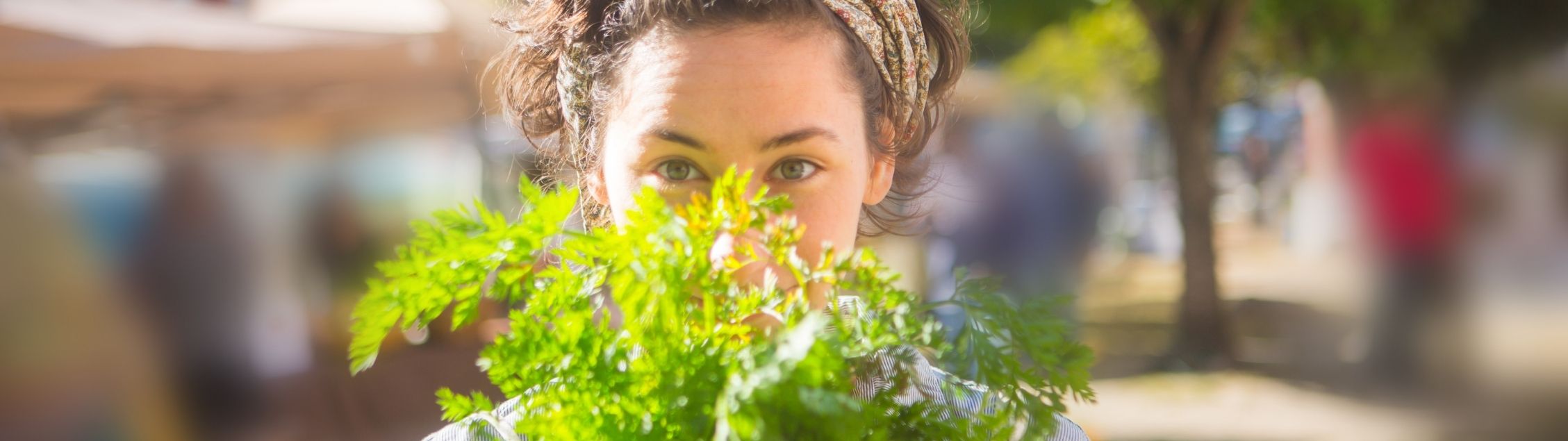Woman holds fresh herbs up to her face
