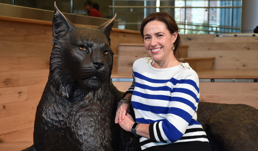 Academic Coordinator poses with a UK wildcat statue